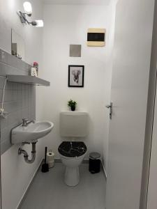 a white bathroom with a toilet and a sink at Ferien und Monteurwohnung mit Garage im Gäu in Gäufelden