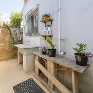 a porch with a wooden bench and potted plants at Doce Lar 58 - Quarto Compartilhado in Cabo de Santo Agostinho
