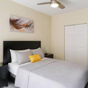 a bedroom with a white bed with a yellow pillow at Cozy Stay in Tampa in Tampa