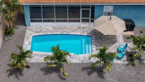 an overhead view of a swimming pool with an umbrella and palm trees at Anna Maria Island-Blue Manatee in Bradenton
