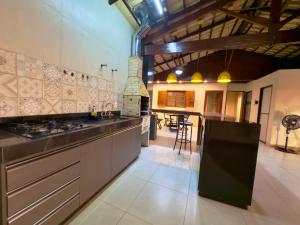 a large kitchen with a stove and a counter top at Cobertura Jacuzzi e Area Gourmet Sao Judas in Divinópolis