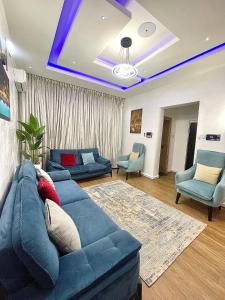 a living room with a blue couch and chairs at The Elegans Apartments in Rubuchi