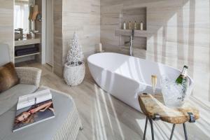 a bathroom with a tub and a bottle of champagne at Gilpin Hotel & Lake House in Bowness-on-Windermere