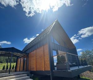 una casa con porte di legno e il sole nel cielo di Pine Chalet Vodice a Vodice