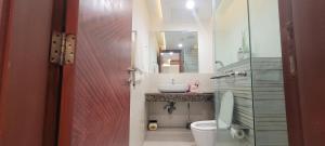 a bathroom with a sink and a toilet and a mirror at Goldcrest Luxury Apartments in Lahore +73 photos