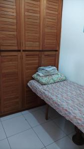Ce lit se trouve dans un dortoir doté d'armoires en bois. dans l'établissement Apartamento Lelis - Descanso para a família e seu pet, pertinho do mar - praia Guarujá - SP, à Guarujá