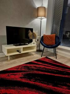 バーミンガムにあるScarlet-Birm City Centre, Free Secure Parking, 2 bedroomのリビングルーム(テレビ、椅子付)