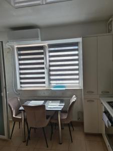 a kitchen with a table and chairs and a window at Fiald-Apartament Nou in Bacău