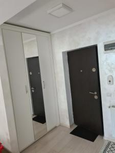 a hallway with two doors and a mirror at Fiald-Apartament Nou in Bacău