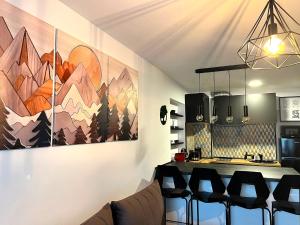 a kitchen and living room with a painting on the wall at Deer House - Self Check-in & Free Parking in Buşteni
