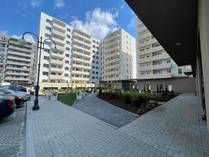 a sidewalk in front of two large white buildings at Apartment in Ploiești 3 in Ploieşti