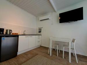 a kitchen with a table and a tv on the wall at Apartment Villa Valentina - Studio 2 in Noord