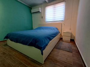 a bedroom with a bed with a blue comforter and a window at Apartment Villa Valentina - Studio 2 in Noord