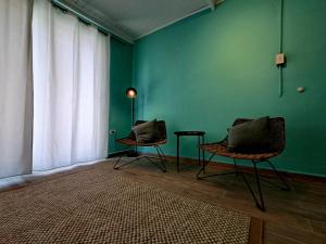 a room with two chairs and a green wall at Apartment Villa Valentina - Studio 2 in Noord
