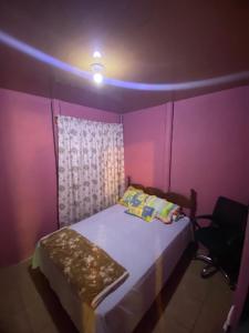 a bedroom with a bed with a purple wall at Hopedale Las Gemelas in Coto Brus