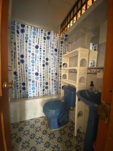 a bathroom with a blue toilet and a sink at Casa de descanso en Doradal Hacienda Napoles in Doradal