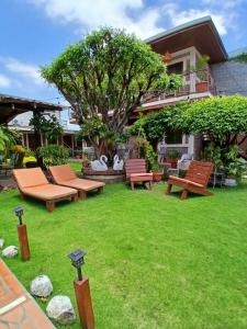 a yard with benches and a tree and a building at Hostal Don Miguel in Rivas +41 photos