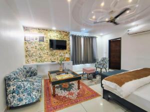 a room with a bed and a couch and a table at Baba Sundaram Hotel in Rīngas
