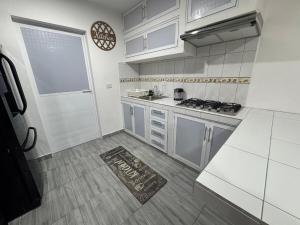 a kitchen with white cabinets and a door and a rug at Modern Cozy Retreat Ideal for Work, Relax & Enjoy in Xalapa