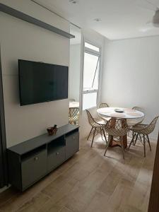 un soggiorno con tavolo e TV a schermo piatto di Stay & Relax Enseada - Guarujá a Guarujá