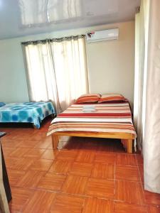 a bedroom with a bed and a wooden floor at inya lodge in Ciudad Cortés