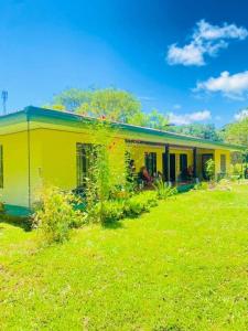 a yellow house with a yard in front of it at inya lodge in Ciudad Cortés