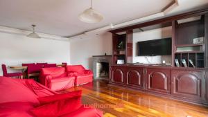 a living room with red furniture and a flat screen tv at Casa em Teresopolis vista para o Dedo de Deus in Teresópolis