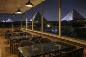 开罗Nefri Pyramids Hotel的夜间餐厅里一排桌椅