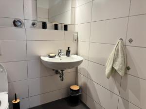 a white bathroom with a sink and a toilet at City-Apartment Kassel Direkt im Zentrum in Kassel +23 photos