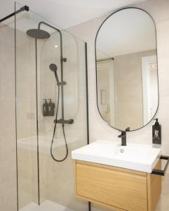 a bathroom with a shower with a sink and a mirror at Dorian Suites in Monforte de Lemos
