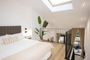 a bedroom with a white bed and a balcony at Dorian Suites in Monforte de Lemos +21 photos