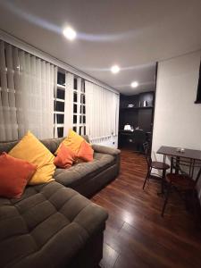 ボゴタにあるapt duplex embajada americana corferias agora g12のリビングルーム(カウチ、黄色とオレンジの枕付)