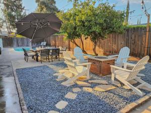 a patio with chairs and a table and an umbrella at Old Fig House - Historic Fig Garden Neighborhood in Fresno