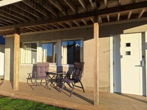a patio with two chairs and a table on a deck at Central and comfortable apartment in Tromsø in Tromsø