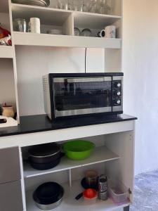 un horno microondas sentado en un estante en una cocina en Casa en el parque, en Necochea