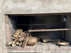 Una chimenea de ladrillo con un estante de madera y cajas. en Casa en el parque, en Necochea