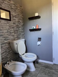 un baño con inodoro y lavabo en Casa en el parque, en Necochea