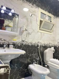 a bathroom with a sink and a toilet at B&KHOME Banha in Banī Ghālib +26 photos