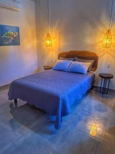 a bedroom with a bed with a blue blanket and two tables at Hotel Huacas in Huacas +49 photos