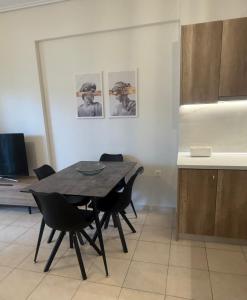 a dining room with a table and black chairs at Domus Philippi & parking in Larisa