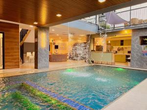 a large swimming pool in a building with a kitchen at Casa DaLuz Hotspring Resort in Los Baños