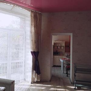 sala de estar con ventana y cocina en Retro House, en Częstochowa