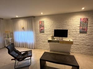 a living room with a tv on a brick wall at Acantilados mar y pileta in Mar del Plata