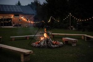 eine Feuerstelle im Garten mit zwei Bänken in der Unterkunft Idzikówka -stodoła in Idzikowice