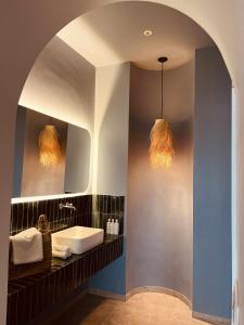 a bathroom with a sink and two pendant lights at Diar Ayoub in Chebba +158 photos