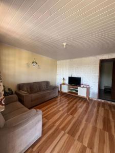 a living room with a couch and a flat screen tv at Chácara vó Zenilda in Itatiaia