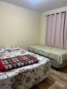 a bedroom with two beds and a window at Chácara vó Zenilda in Itatiaia +5 photos