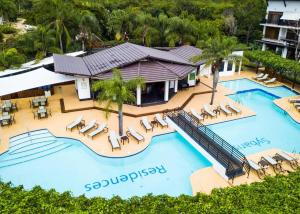 フアン・ドリオにあるApartamento confortable cerca de la playa y aeropuertoのリゾートのスイミングプール(ラウンジチェア付)を一望できます。 +7枚の写真