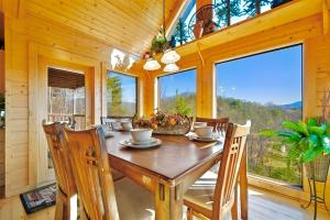 a dining room with a wooden table and chairs at Little Cub Cabin I Spacious Exquisite View 3 King Hot Tub & BBQ in Sevierville