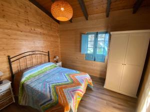 a bedroom with a bed in a wooden cabin at Hacienda el Capricho in Cartaya